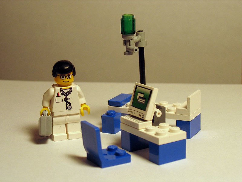 Imagem contendo brinquedo LEGO de médico em um consultório médico de brinquedo