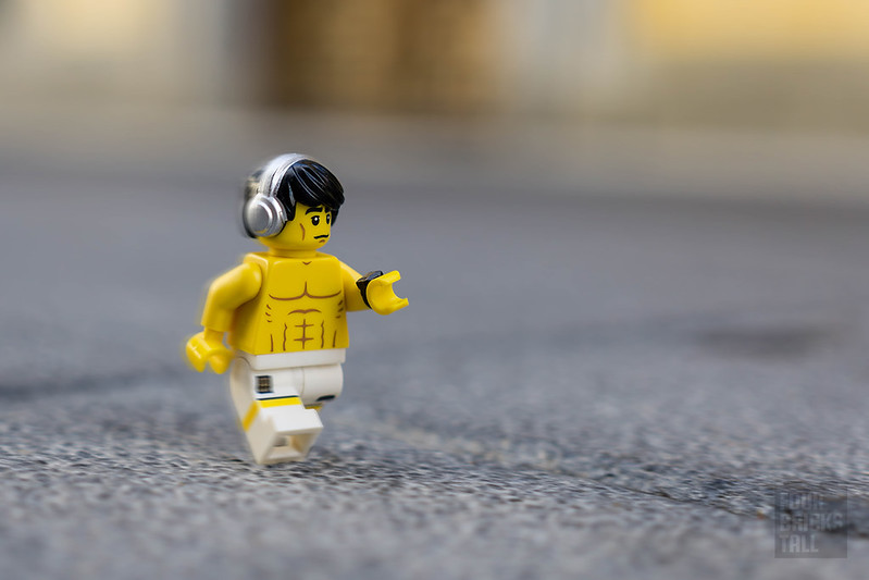 Imagem com um LEGO sem camisa caminhando com fone de ouvido